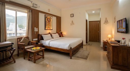 Spacious AC Deluxe pilgrim room with twin beds and clean attached bathroom at Nandakam Rest House